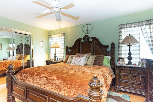 bedroom featuring ceiling fan, a closet, and light hardwood / wood-style flooring