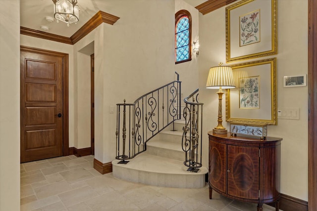 foyer entrance featuring a notable chandelier and ornamental molding