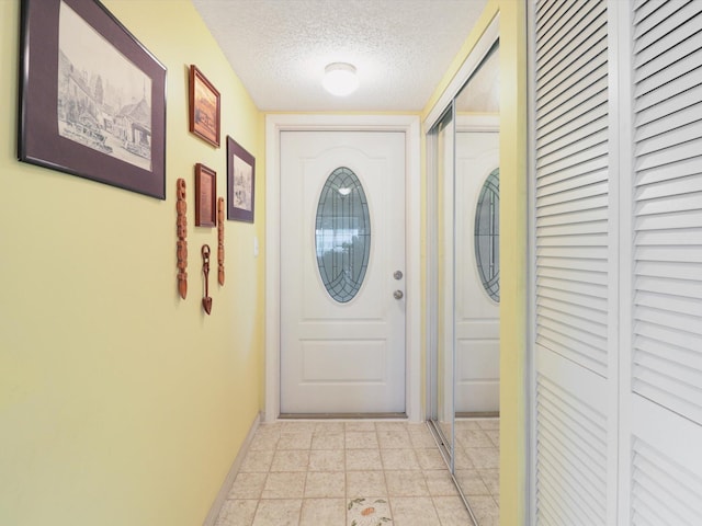 entryway featuring a textured ceiling and light tile flooring