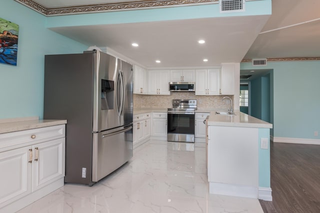 kitchen featuring kitchen peninsula, stainless steel appliances, tasteful backsplash, white cabinets, and light tile floors