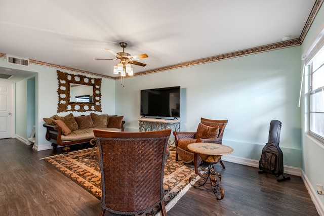 living room featuring dark hardwood / wood-style floors, ceiling fan, and ornamental molding