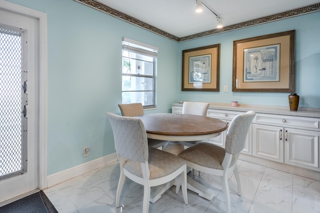 dining space featuring rail lighting and light tile floors