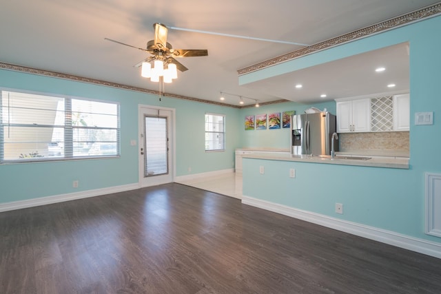 interior space with sink, ceiling fan, a healthy amount of sunlight, and dark hardwood / wood-style floors