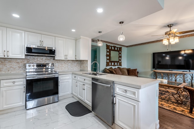 kitchen featuring kitchen peninsula, stainless steel appliances, tasteful backsplash, sink, and light wood-type flooring