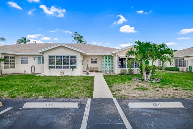 single story home with a front lawn