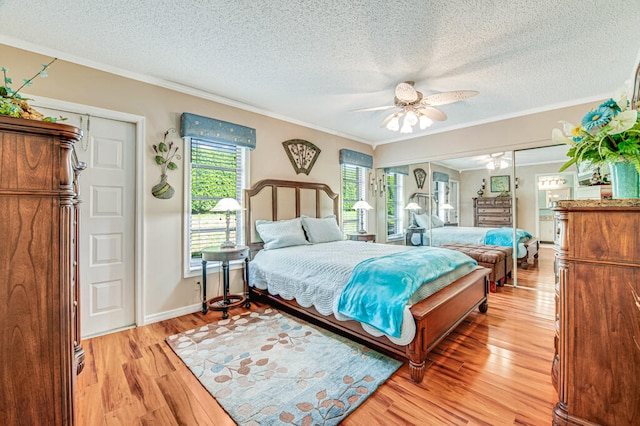 bedroom featuring ornamental molding, light hardwood / wood-style flooring, ceiling fan, and a textured ceiling