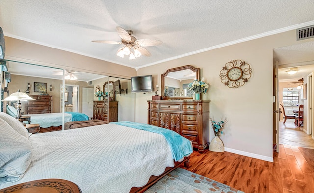 tiled bedroom featuring a closet, ceiling fan, crown molding, and a textured ceiling