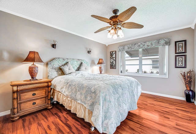 bedroom with crown molding, dark hardwood / wood-style flooring, ceiling fan, and a textured ceiling