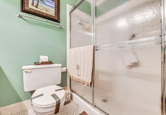 bathroom with an enclosed shower, toilet, and tile floors