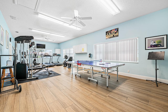 recreation room featuring light hardwood / wood-style floors, ceiling fan, and a textured ceiling