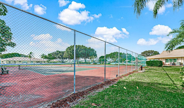 view of tennis court with a yard