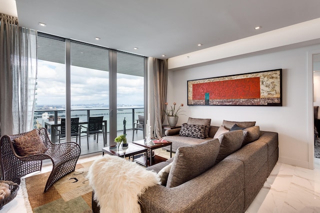 tiled living room featuring floor to ceiling windows and a water view