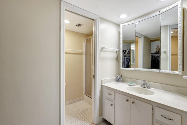 bathroom featuring vanity, a shower with shower door, and tile patterned floors