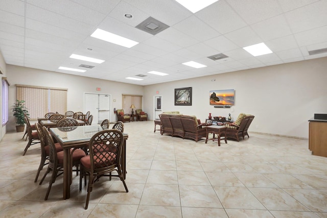 tiled dining room with a paneled ceiling