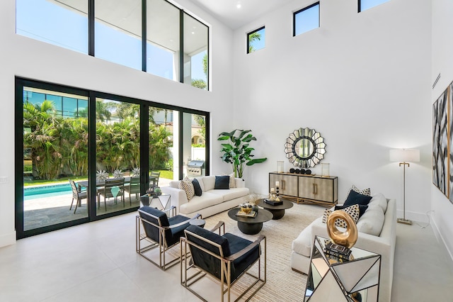 tiled living room featuring a healthy amount of sunlight and a towering ceiling