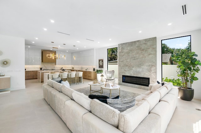 living room with tile walls, light tile flooring, and a premium fireplace