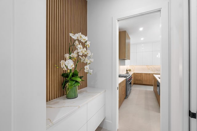 interior space with tasteful backsplash, vanity, tile floors, and a bathtub