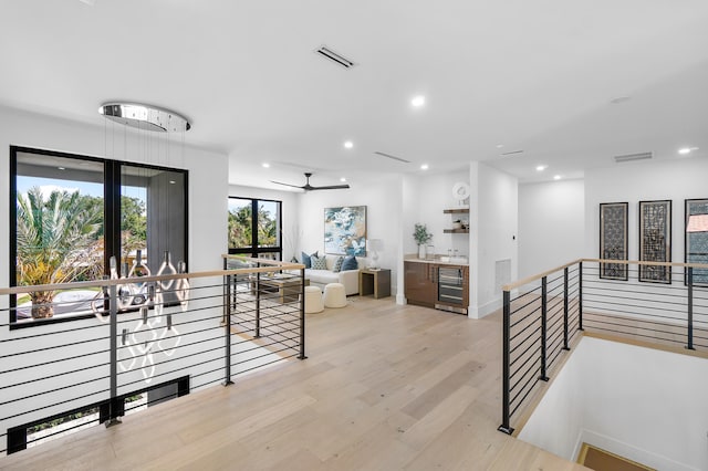 hallway with beverage cooler and light hardwood / wood-style flooring