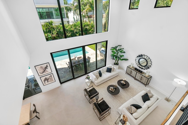 living room with a towering ceiling and tile flooring