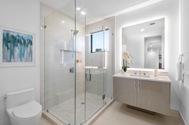 bathroom featuring vanity with extensive cabinet space, a shower with door, toilet, and tile floors