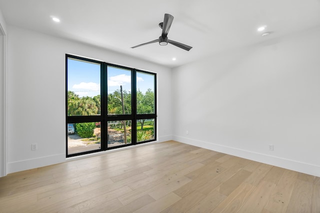 spare room with ceiling fan and light wood-type flooring