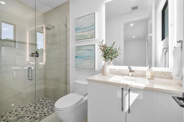 bathroom with a shower with door, vanity, and toilet