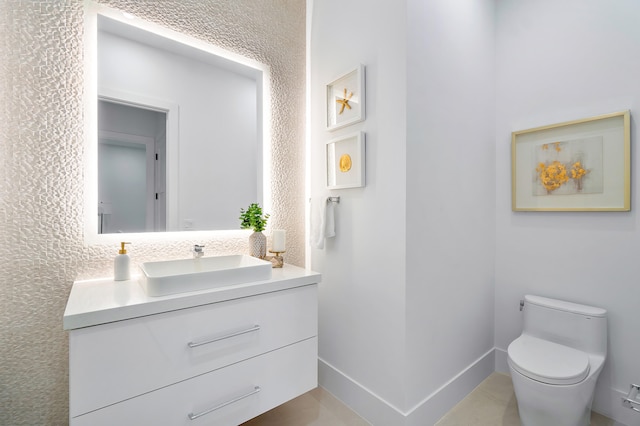 bathroom with toilet, tile floors, and vanity