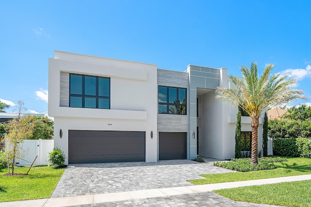 contemporary house featuring a garage and a front lawn