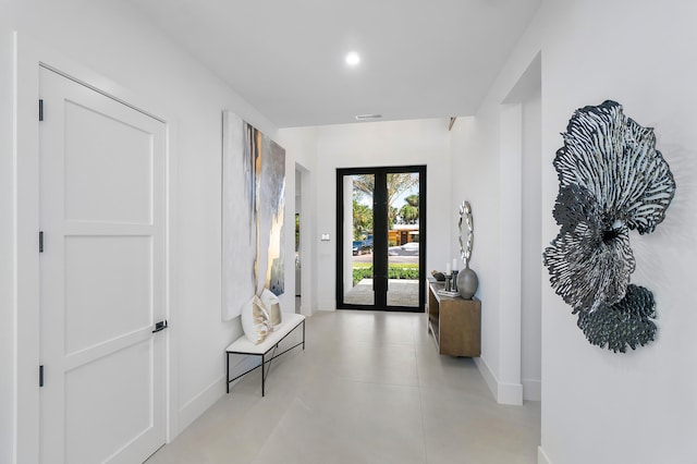 hall with french doors and light tile floors