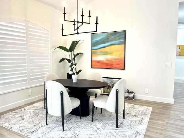 dining area featuring hardwood / wood-style floors and a notable chandelier