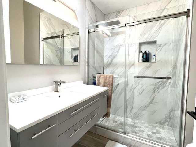 bathroom featuring wood-type flooring, vanity, and a shower with door