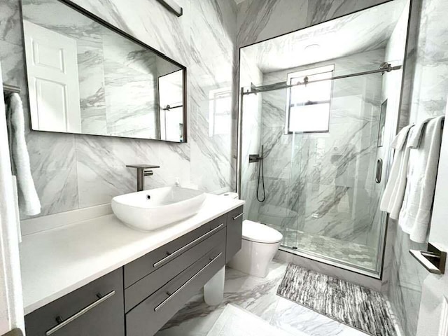 full bathroom with marble finish floor, toilet, vanity, and a marble finish shower