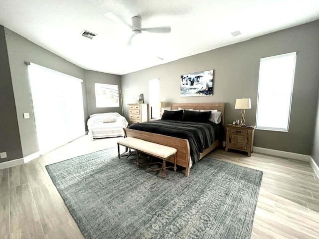 bedroom with visible vents, ceiling fan, baseboards, and wood finished floors