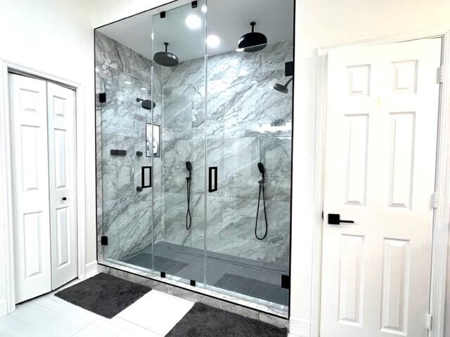 full bathroom featuring a marble finish shower