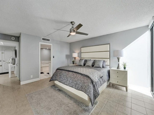 tiled bedroom featuring ceiling fan, ensuite bathroom, and a textured ceiling