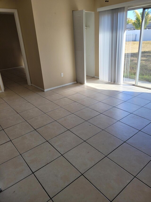 kitchen with light tile patterned floors, light brown cabinets, sink, and white fridge