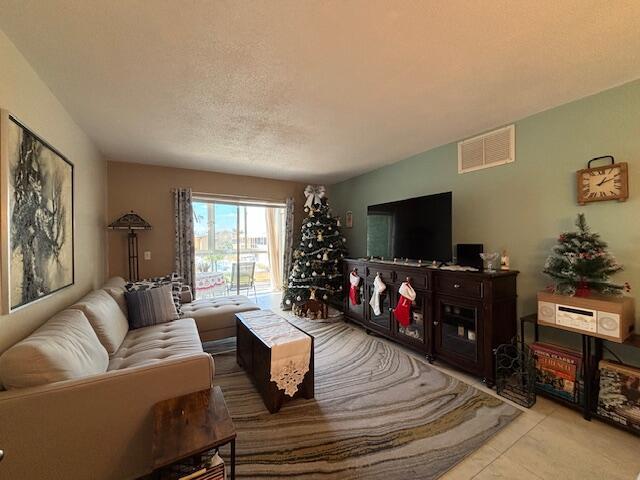 living room with light tile patterned flooring and a textured ceiling