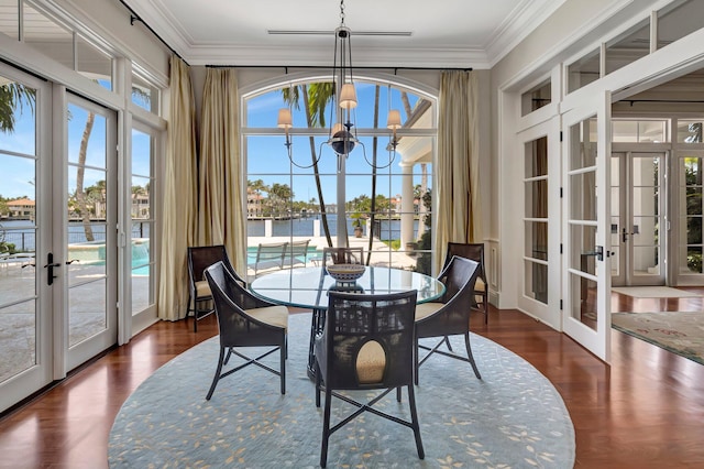 sunroom / solarium featuring french doors and an inviting chandelier