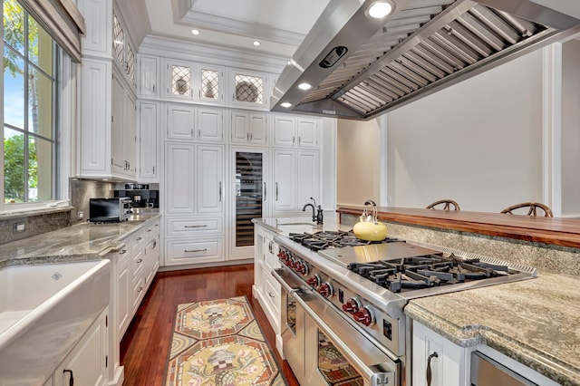 kitchen with custom range hood, dark hardwood / wood-style flooring, double oven range, and white cabinets