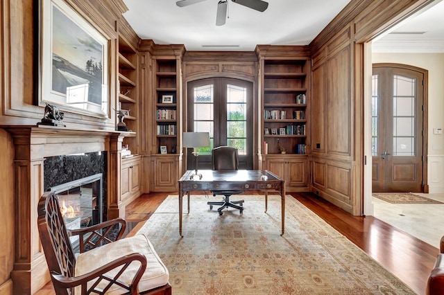 office area featuring ceiling fan, built in features, light hardwood / wood-style flooring, and a fireplace