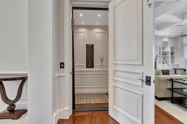 interior space featuring coffered ceiling and light wood-type flooring