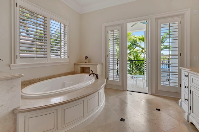 bathroom with tile flooring, plenty of natural light, ornamental molding, and a bath