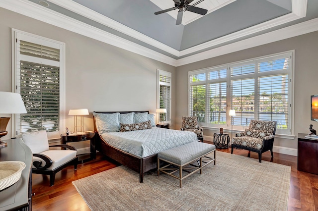 bedroom featuring crown molding, wood-type flooring, ceiling fan, and a raised ceiling