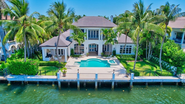 rear view of property with a water view and a patio