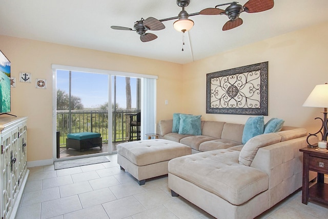 living area featuring light tile patterned floors, ceiling fan, and baseboards