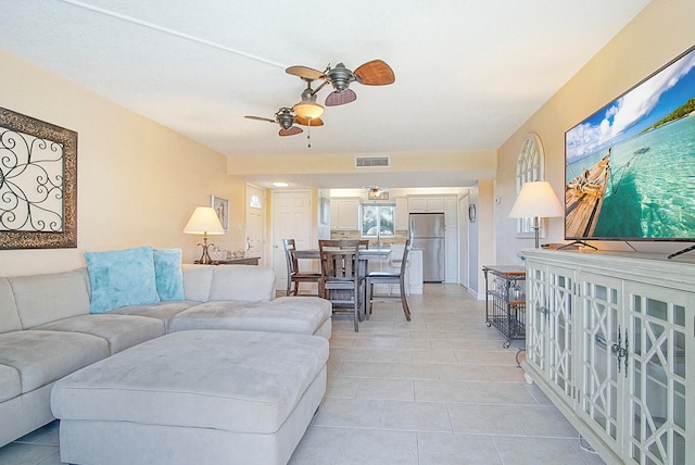 living area featuring light tile patterned floors, visible vents, and a ceiling fan