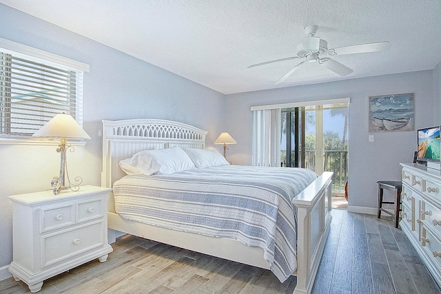 bedroom with ceiling fan, access to outside, light wood-style flooring, and a textured ceiling