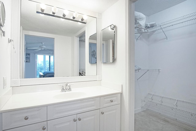 bathroom featuring ceiling fan, a textured ceiling, and large vanity