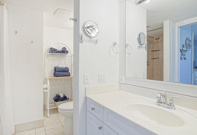 bathroom with a textured ceiling, vanity with extensive cabinet space, toilet, and tile flooring