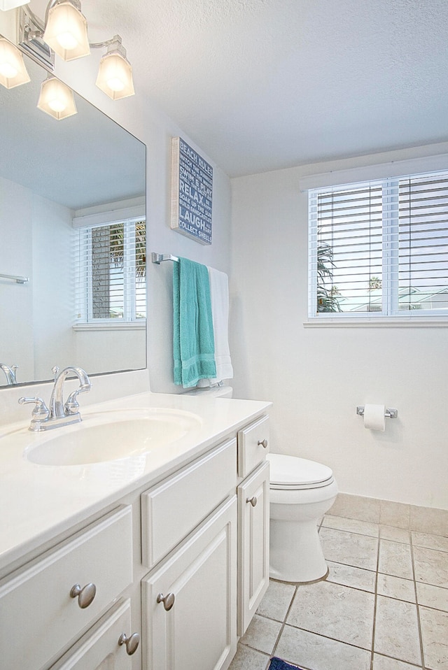 bathroom featuring a textured ceiling, vanity, toilet, and tile patterned floors